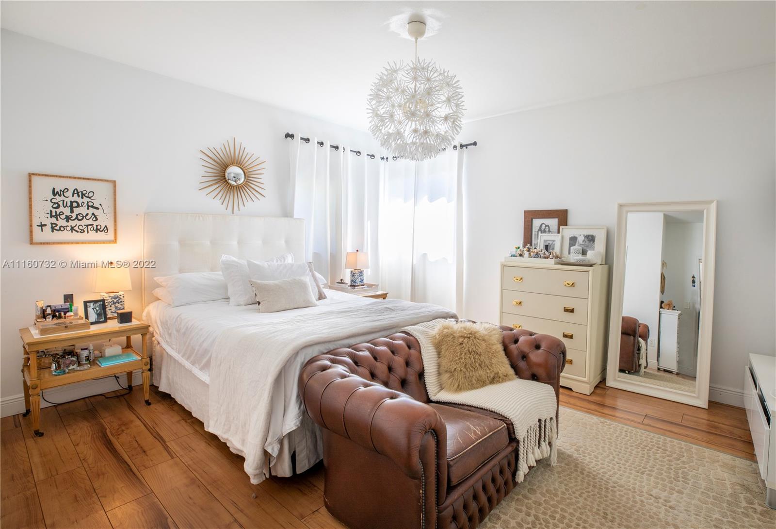 4216 Alton Road Miami Beach, FL 33140 - Photo 10 of 27 a bedroom with a bed and a chandelier