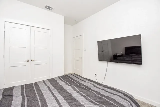 a bedroom with a bed and a flat screen tv