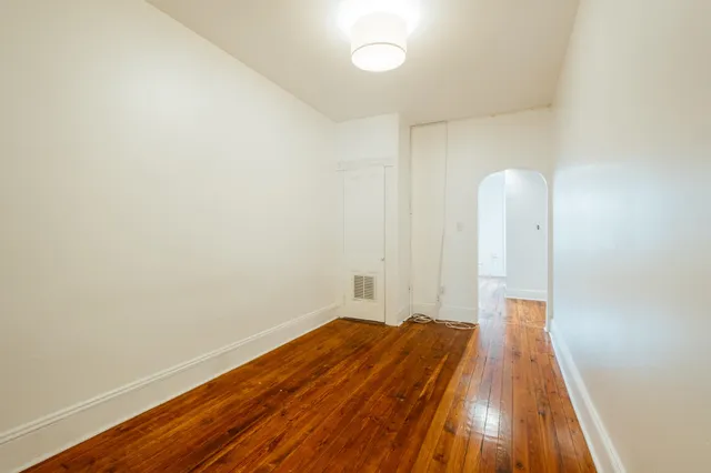 a view of a room with wooden floor and a ceiling fan