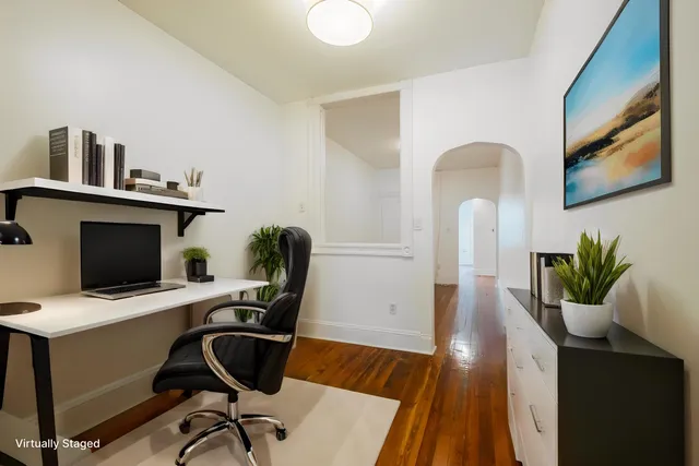 a view of a workspace with furniture and wooden floor