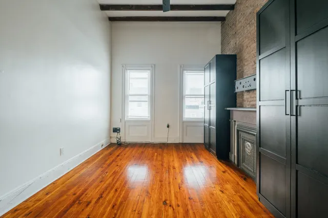 a view of a kitchen with wooden floor electronic appliances and windows