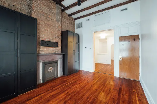 a view of a hallway with wooden floor and a fireplace