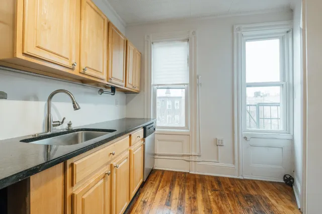 a kitchen with granite countertop a sink and cabinets