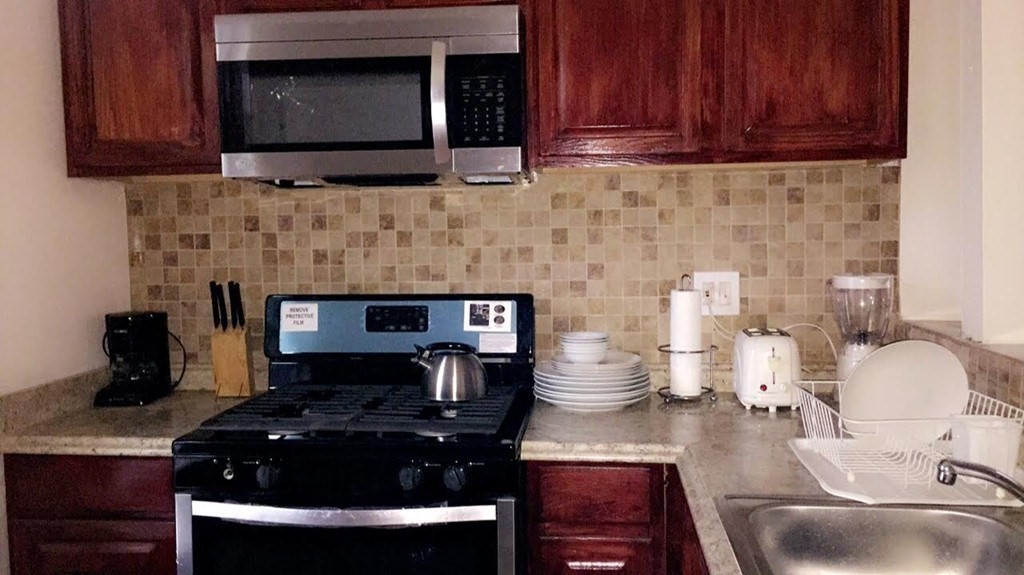 36 Gordon Street Boston, MA 02134 - Photo 2 of 14 a kitchen with a stove a microwave a sink and cabinets