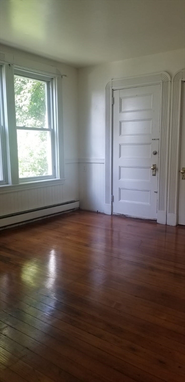 36 Gordon Street Boston, MA 02134 - Photo 7 of 14 an empty room with wooden floor cabinet and windows