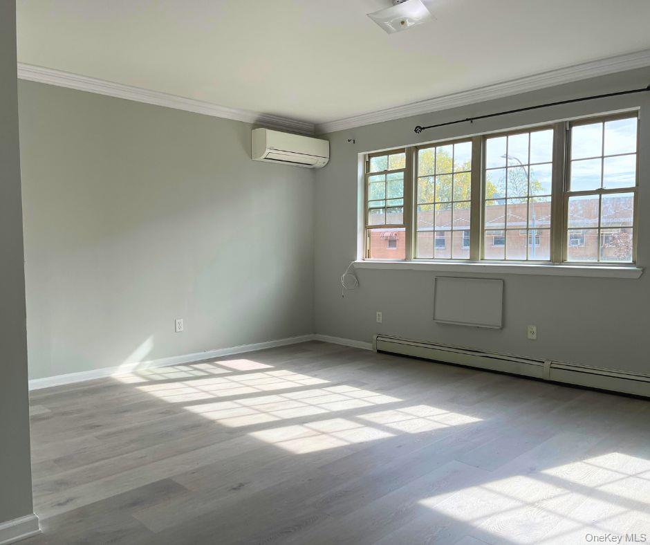 1467 Saint Marks Avenue, Unit 6 Brooklyn, NY 11233 - Photo 2 of 8 an empty room with wooden floor and windows