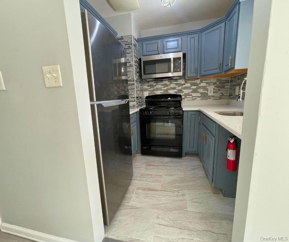 1467 Saint Marks Avenue, Unit 6 Brooklyn, NY 11233 - Photo 3 of 8 a kitchen with a refrigerator stove and microwave