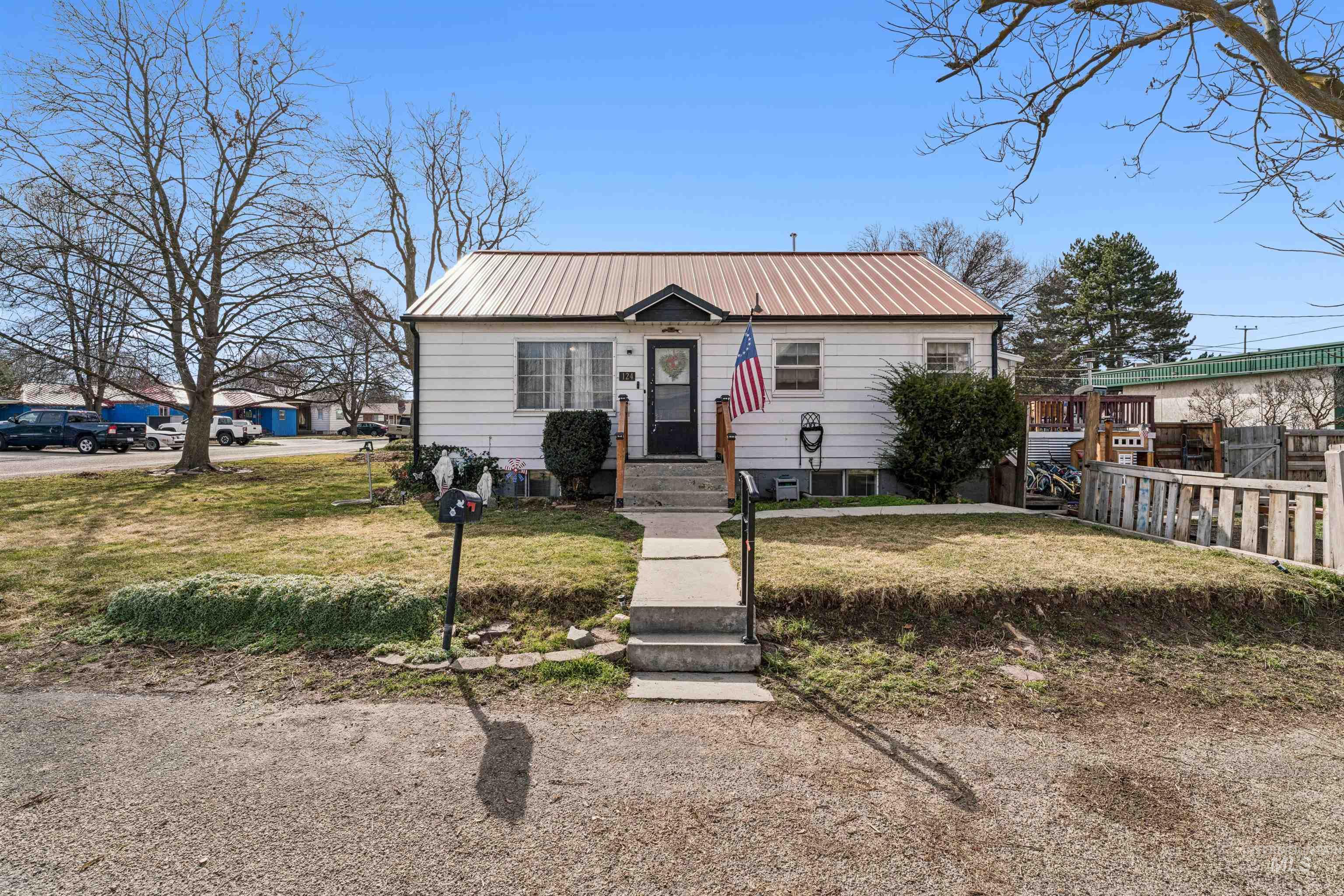 Bungalow with a front yard and a metal roof