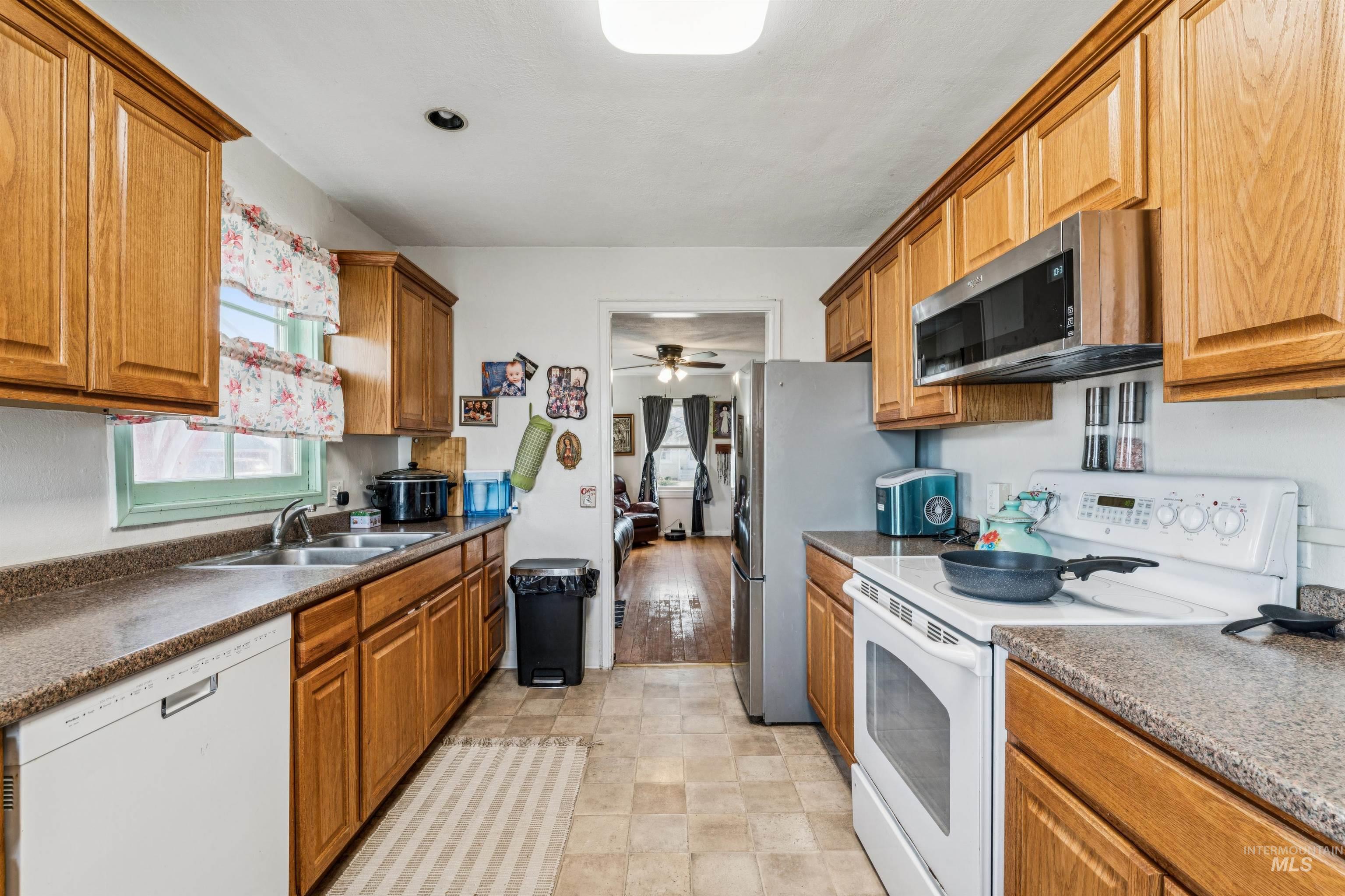 124 Halstead Street Caldwell, ID 83605 - Photo 19 of 42 Kitchen with stainless steel appliances, wood finish cabinets, dark countertops, and a ceiling fan