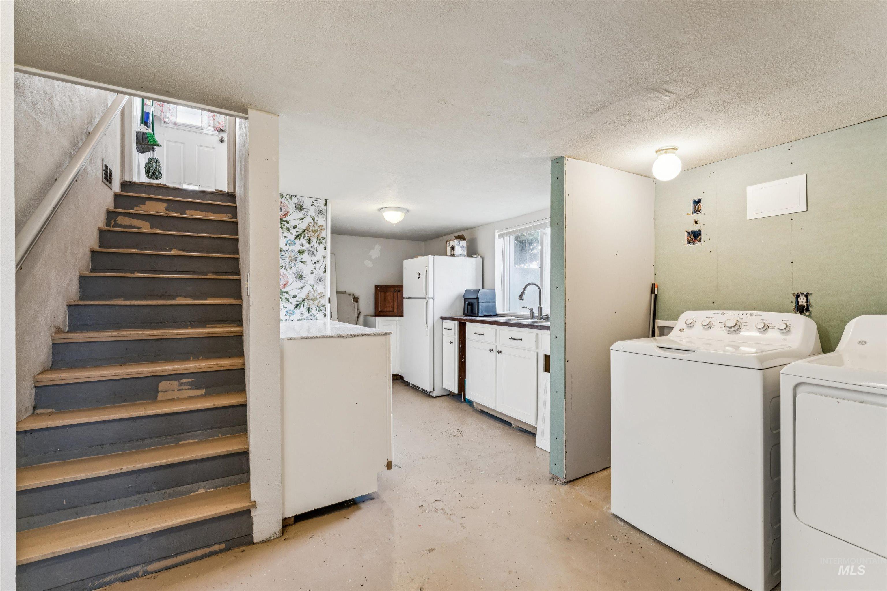 124 Halstead Street Caldwell, ID 83605 - Photo 20 of 42 Laundry area with concrete floors, washing machine and clothes dryer, and a textured ceiling