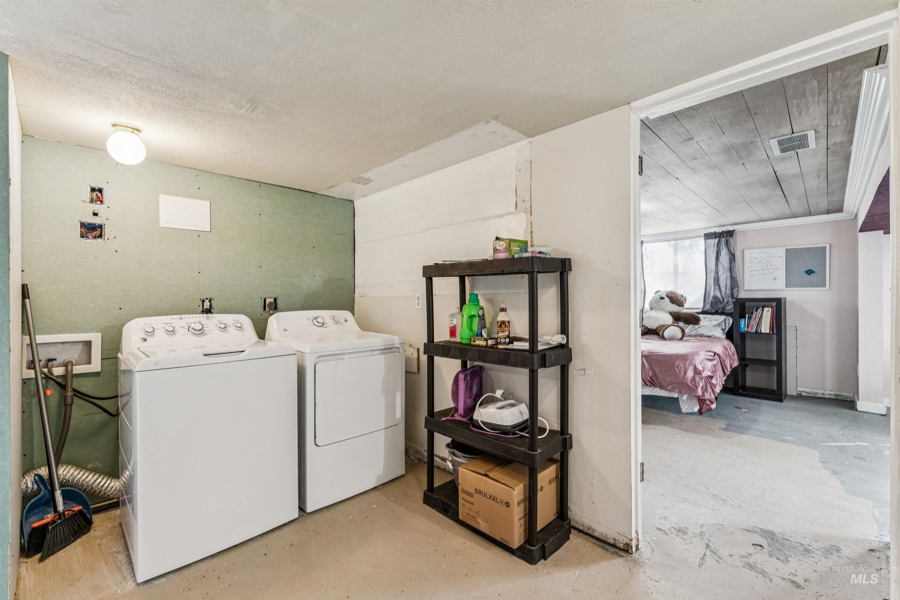 124 Halstead Street Caldwell, ID 83605 - Photo 24 of 42 Laundry area with unfinished concrete flooring and washing machine and dryer