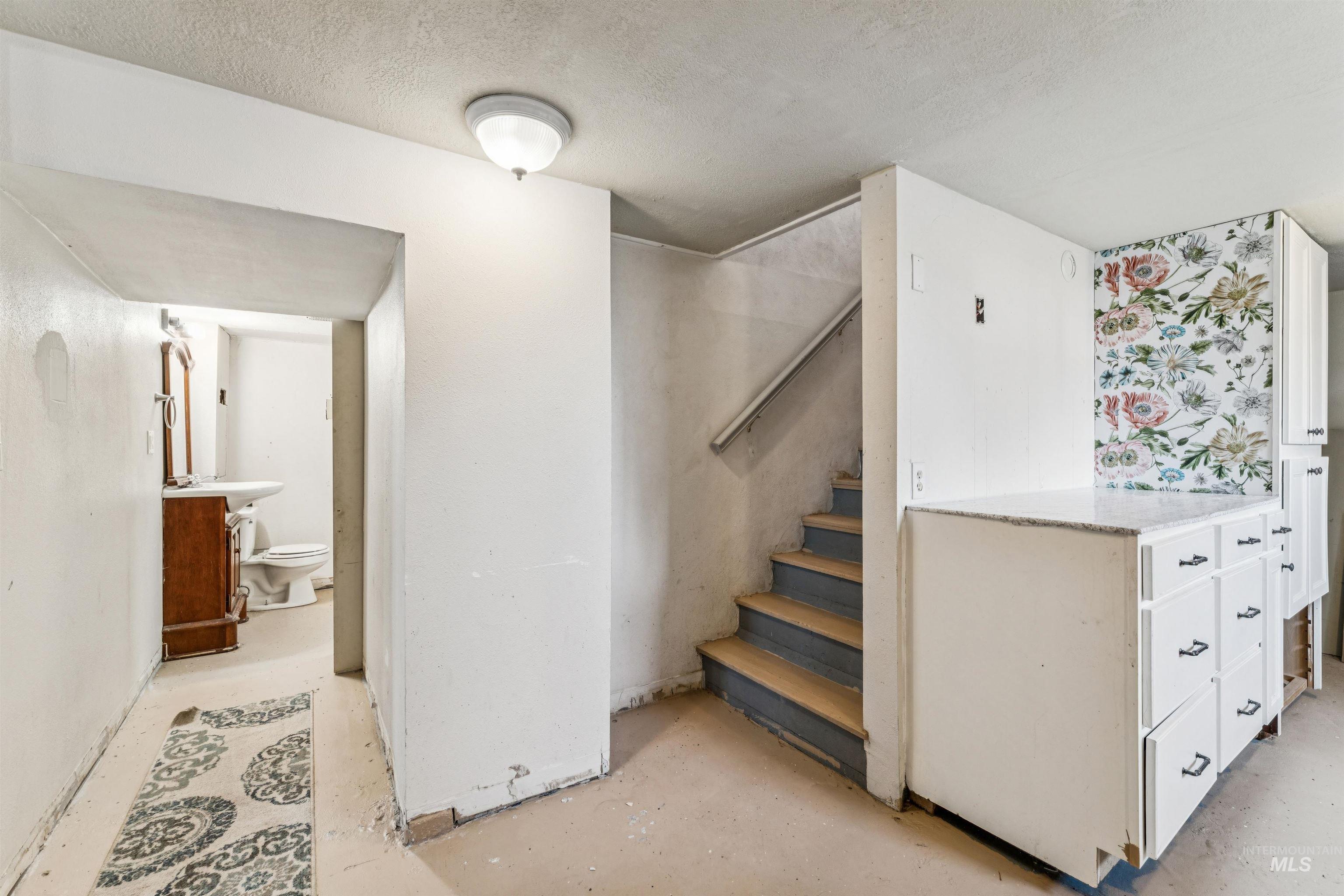124 Halstead Street Caldwell, ID 83605 - Photo 30 of 42 Staircase with unfinished concrete floors and a textured ceiling