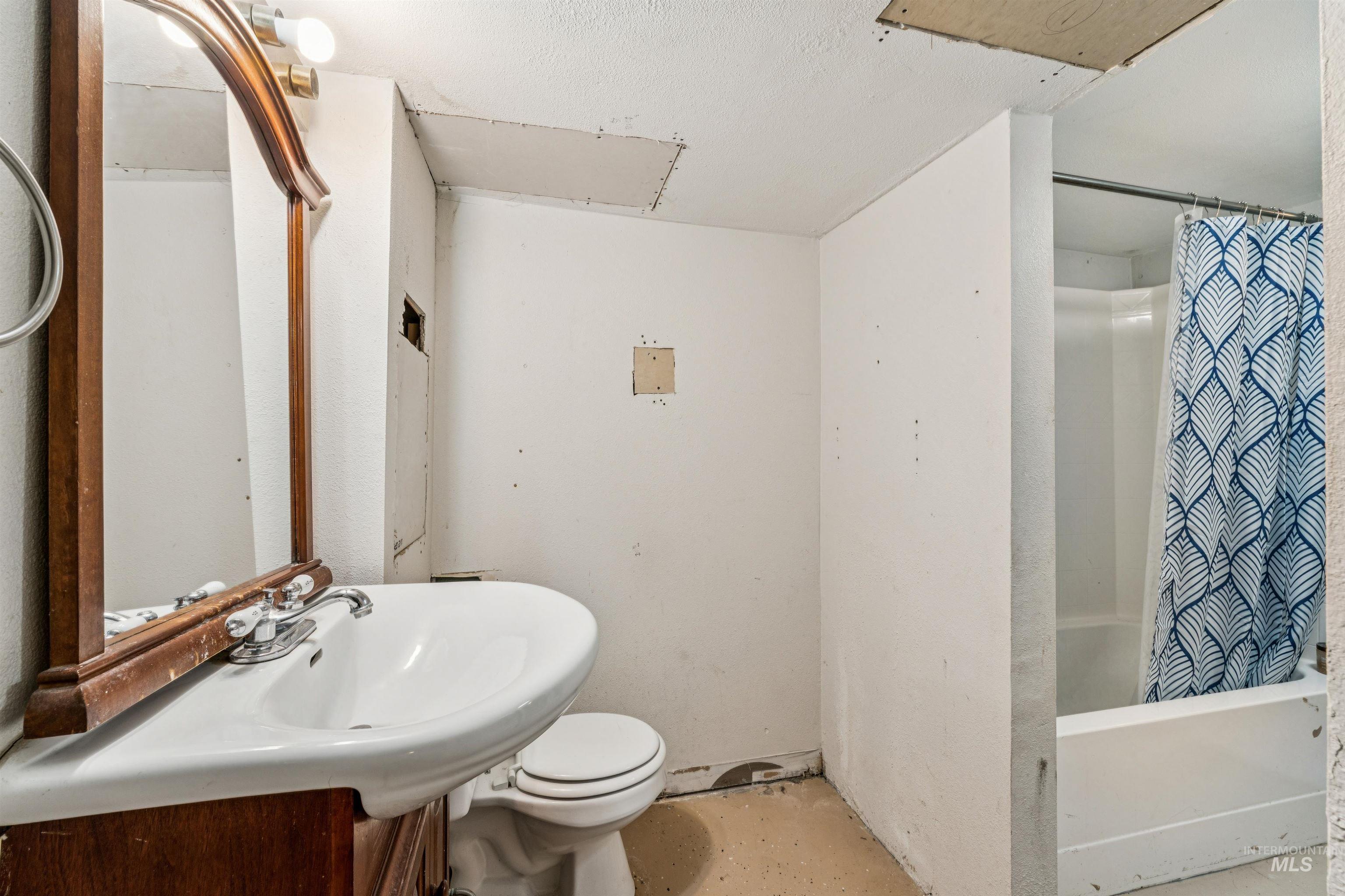 124 Halstead Street Caldwell, ID 83605 - Photo 31 of 42 Bathroom with shower / bath combination with curtain, concrete floors, and vanity