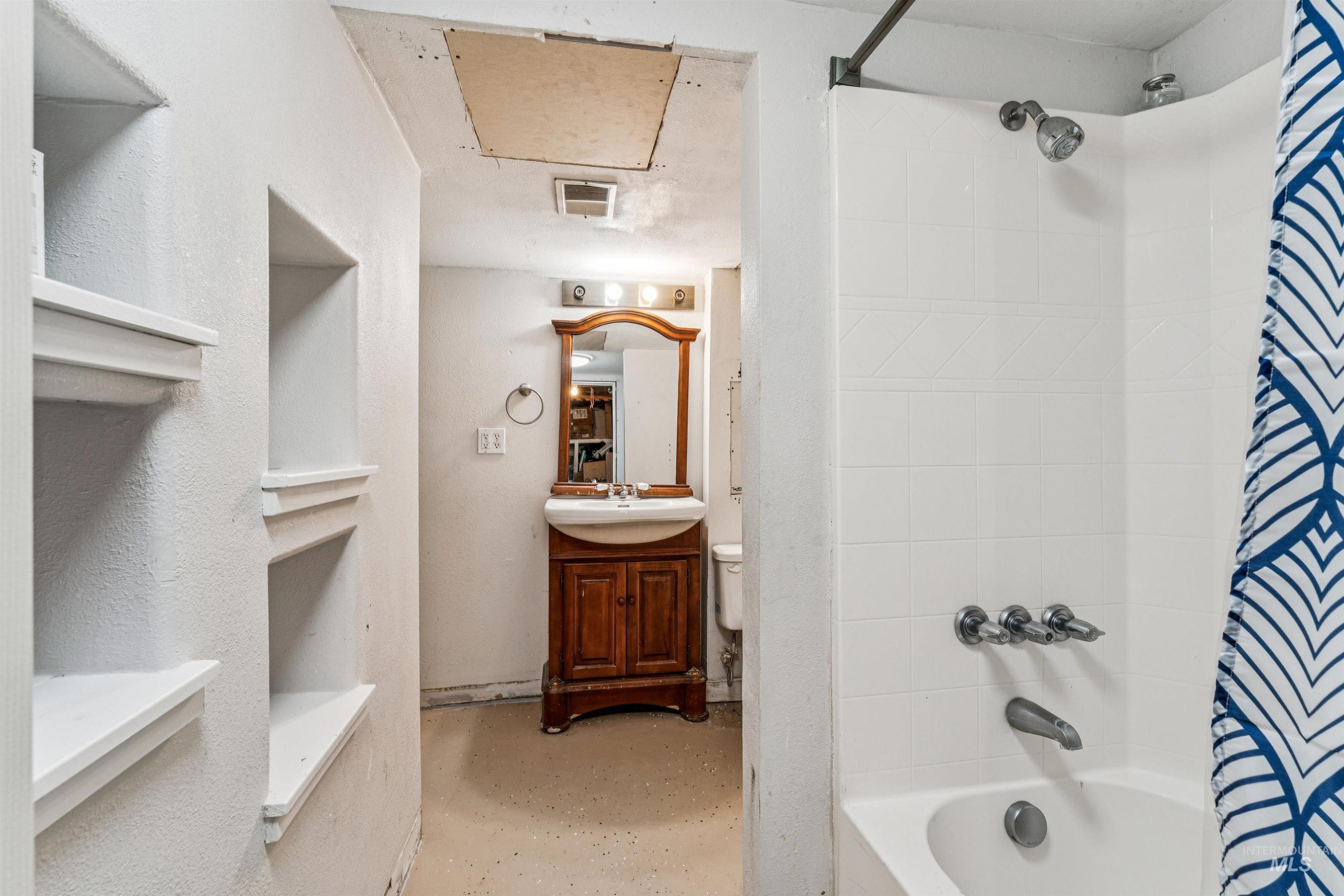 124 Halstead Street Caldwell, ID 83605 - Photo 32 of 42 Bathroom with vanity, shower / tub combo with curtain, and concrete floors