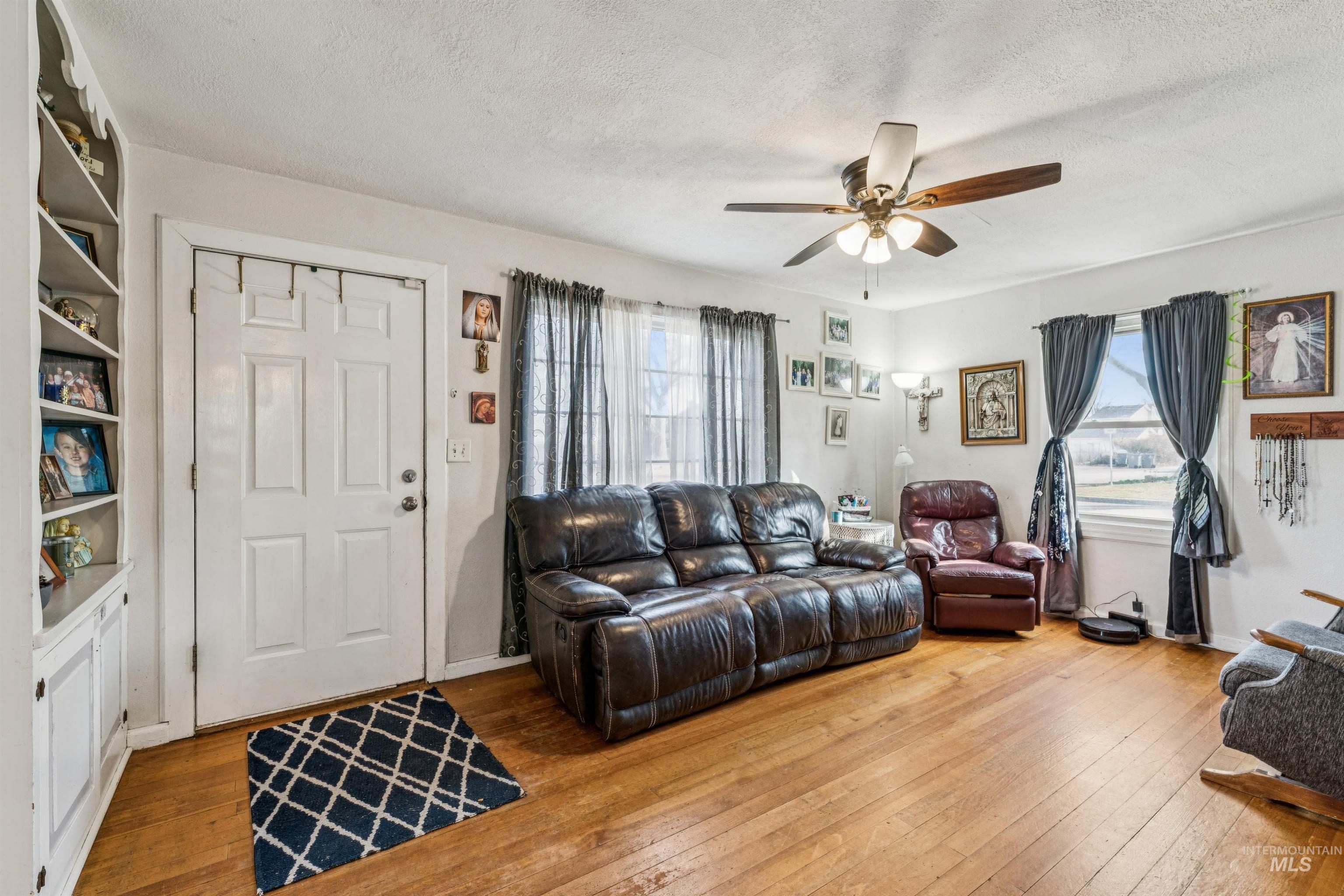 124 Halstead Street Caldwell, ID 83605 - Photo 4 of 42 Living room featuring hardwood / wood-style flooring, healthy amount of natural light, a ceiling fan, and a textured ceiling