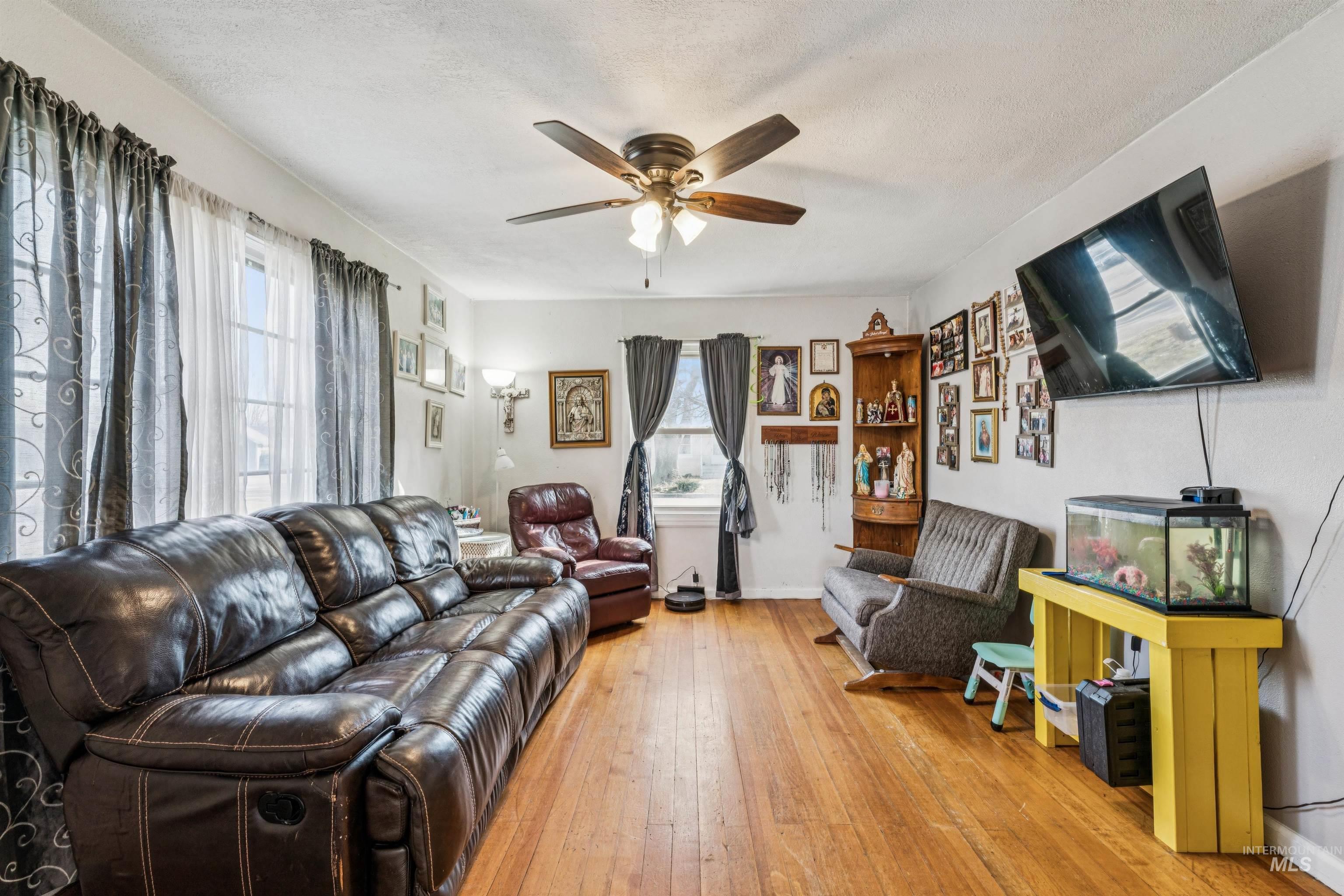 124 Halstead Street Caldwell, ID 83605 - Photo 5 of 42 Living area with light wood finished floors, a ceiling fan, and a textured ceiling