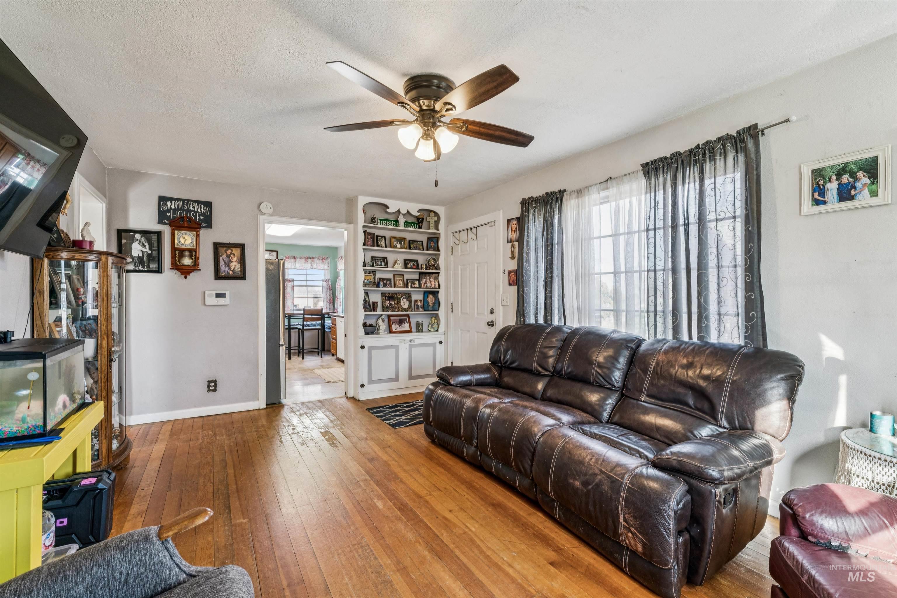 124 Halstead Street Caldwell, ID 83605 - Photo 6 of 42 Living room with wood-type flooring, a ceiling fan, and a textured ceiling