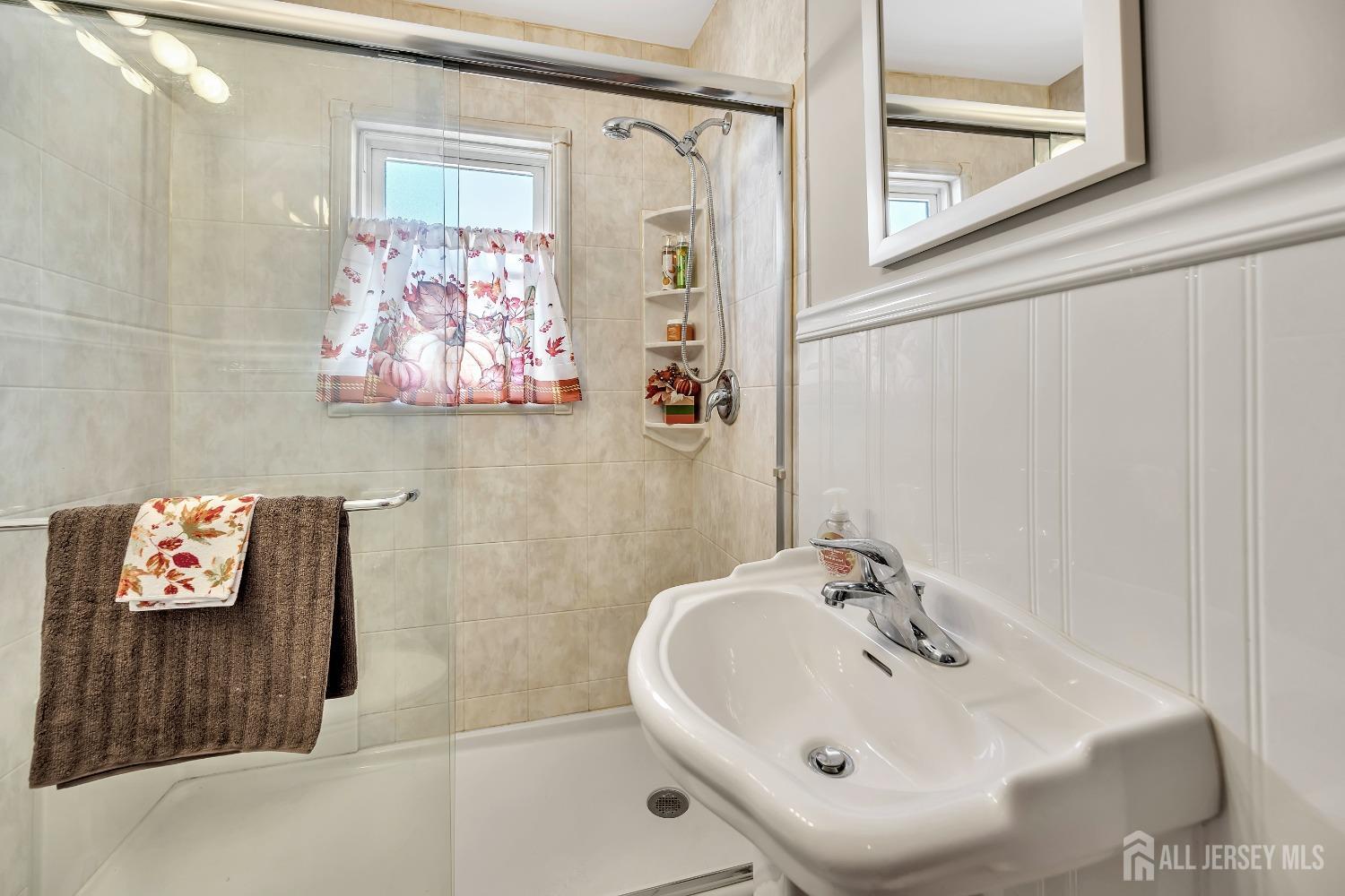 446 2nd Street Dunellen, NJ 08812 - Photo 20 of 31 a bathroom with a sink a mirror and a shower