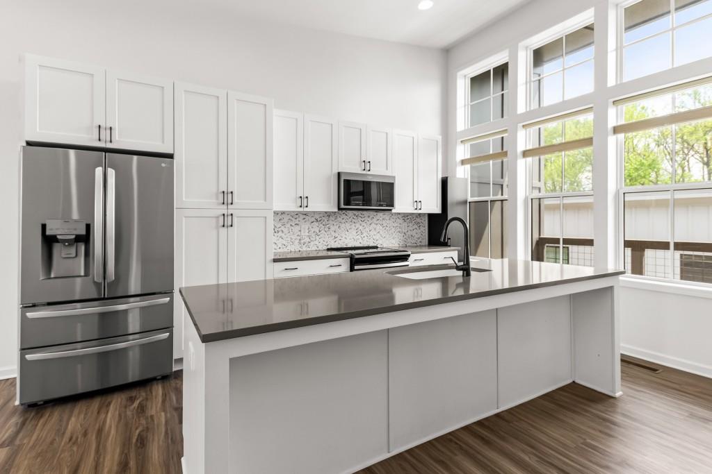 a kitchen with stainless steel appliances a refrigerator sink and microwave