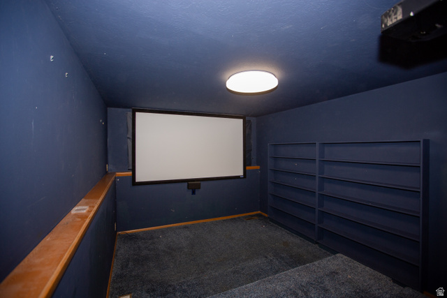 1500 Sumac Drive Logan, UT 84321 - Photo 37 of 42 Dedicated entertainment space featuring a projection screen, ceiling-mounted projector, and two walls of built-in shelving