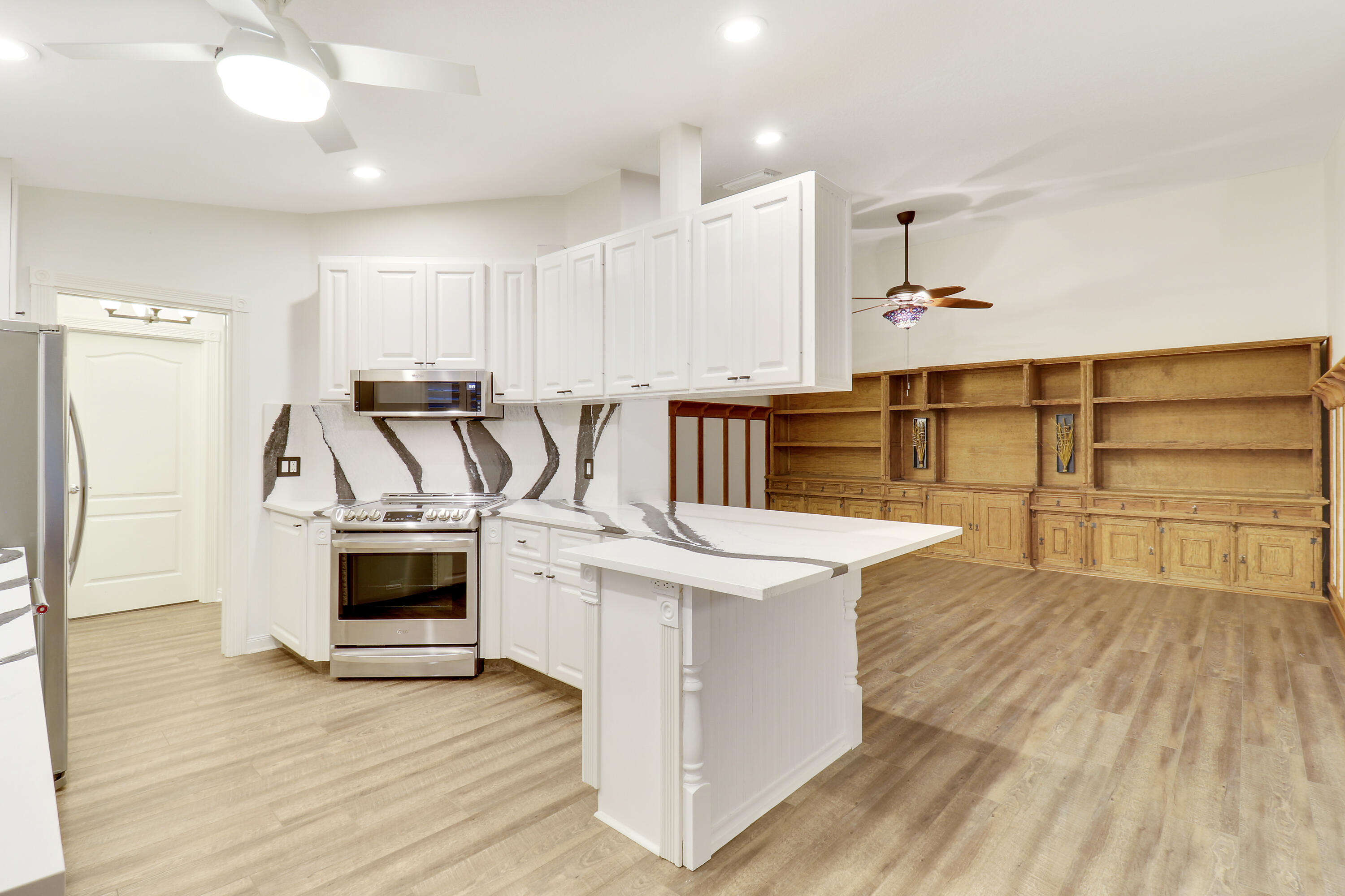 918 Southwest Balmoral Trace Stuart, FL 34997 - Photo 2 of 20 a kitchen with stainless steel appliances kitchen island wooden floors and white cabinets