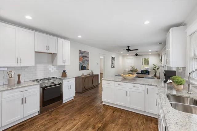 a large white kitchen with a refrigerator a stove a sink and a cabinets