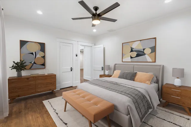 an empty room with wooden floor and ceiling fan