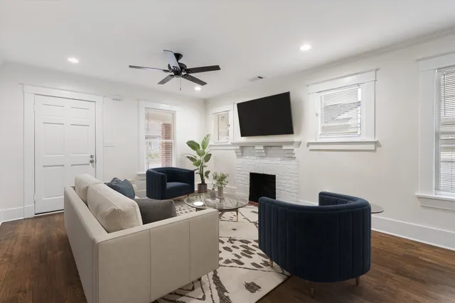 an empty room with windows and fireplace