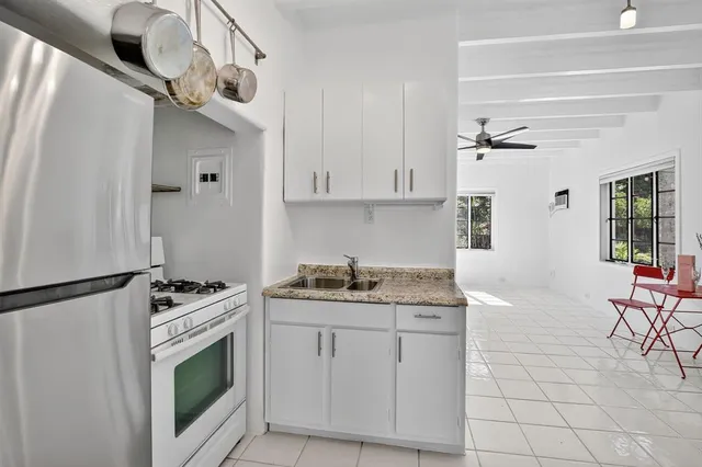 a kitchen with stainless steel appliances granite countertop a stove a sink and a refrigerator
