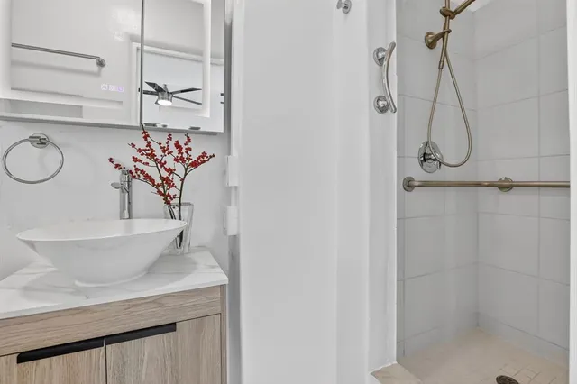 a bathroom with a granite countertop sink a toilet and shower
