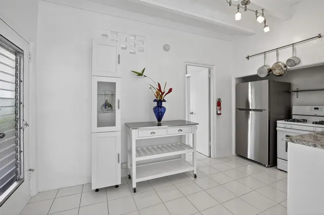 a kitchen with white cabinets and refrigerator