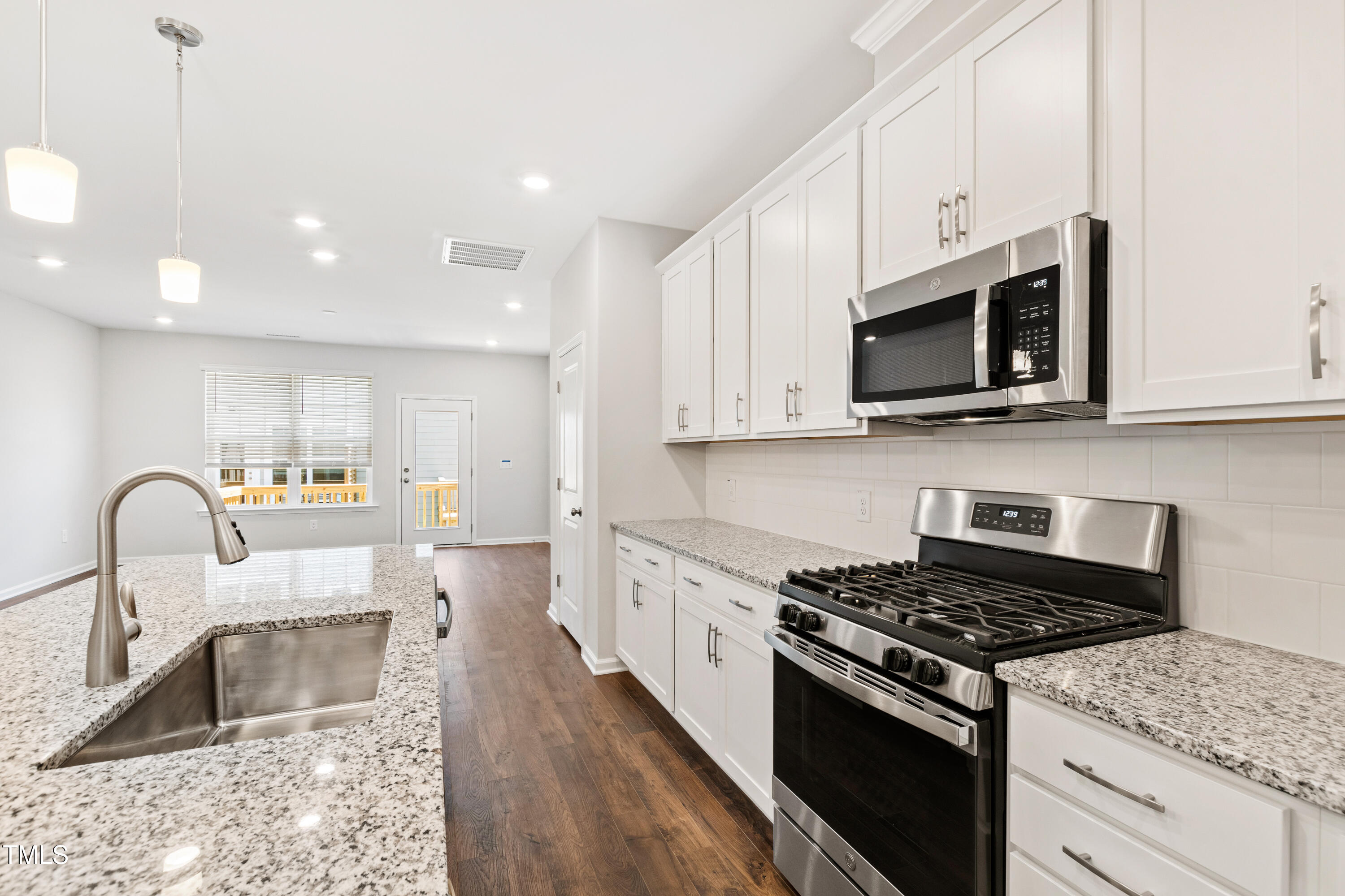 1102 Harmony Trail Durham, NC 27703 - Photo 5 of 33 a kitchen with granite countertop a stove and a sink