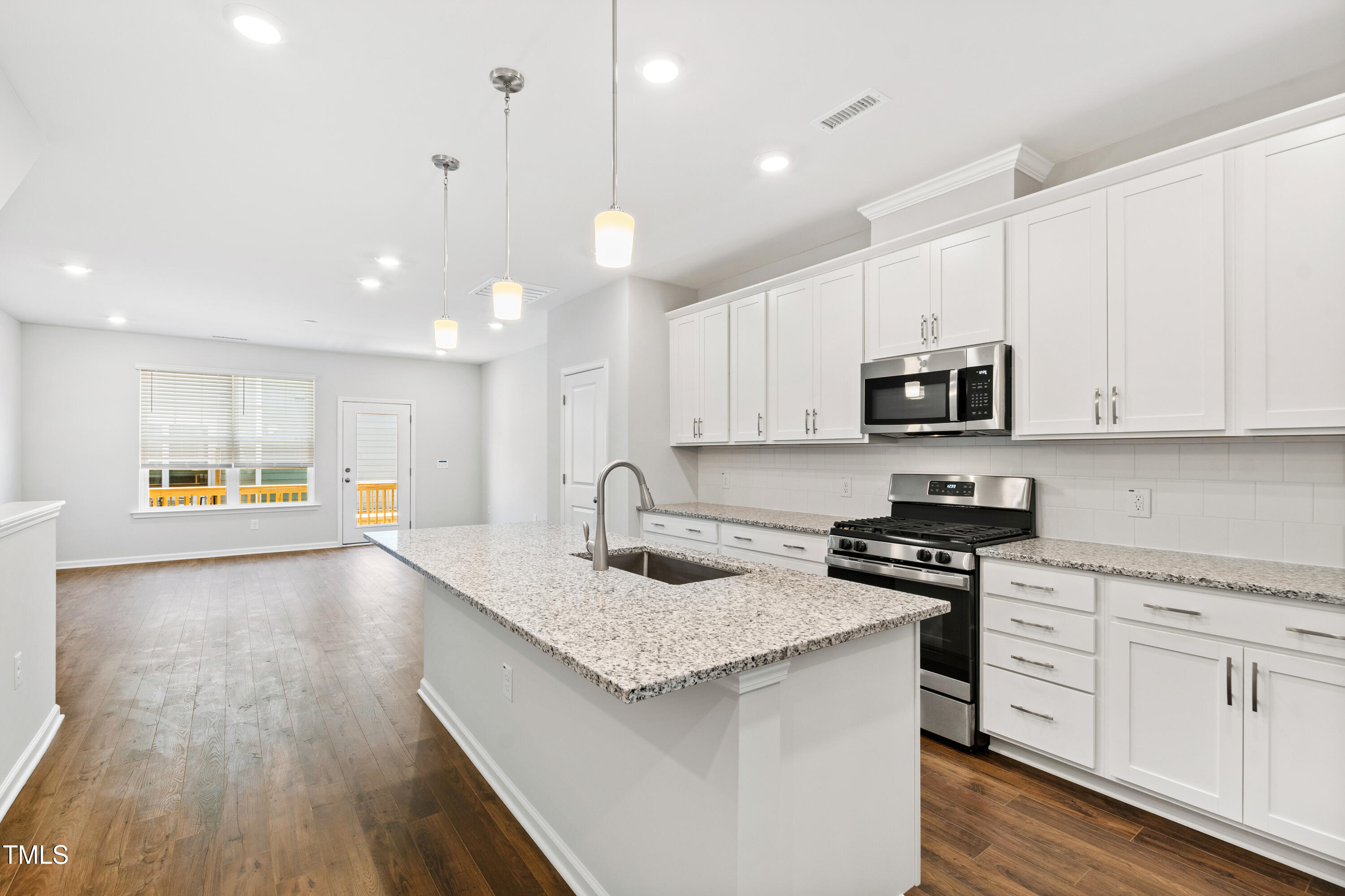 1102 Harmony Trail Durham, NC 27703 - Photo 6 of 33 a kitchen with stainless steel appliances granite countertop a stove top oven a sink a refrigerator white cabinets and wooden floor