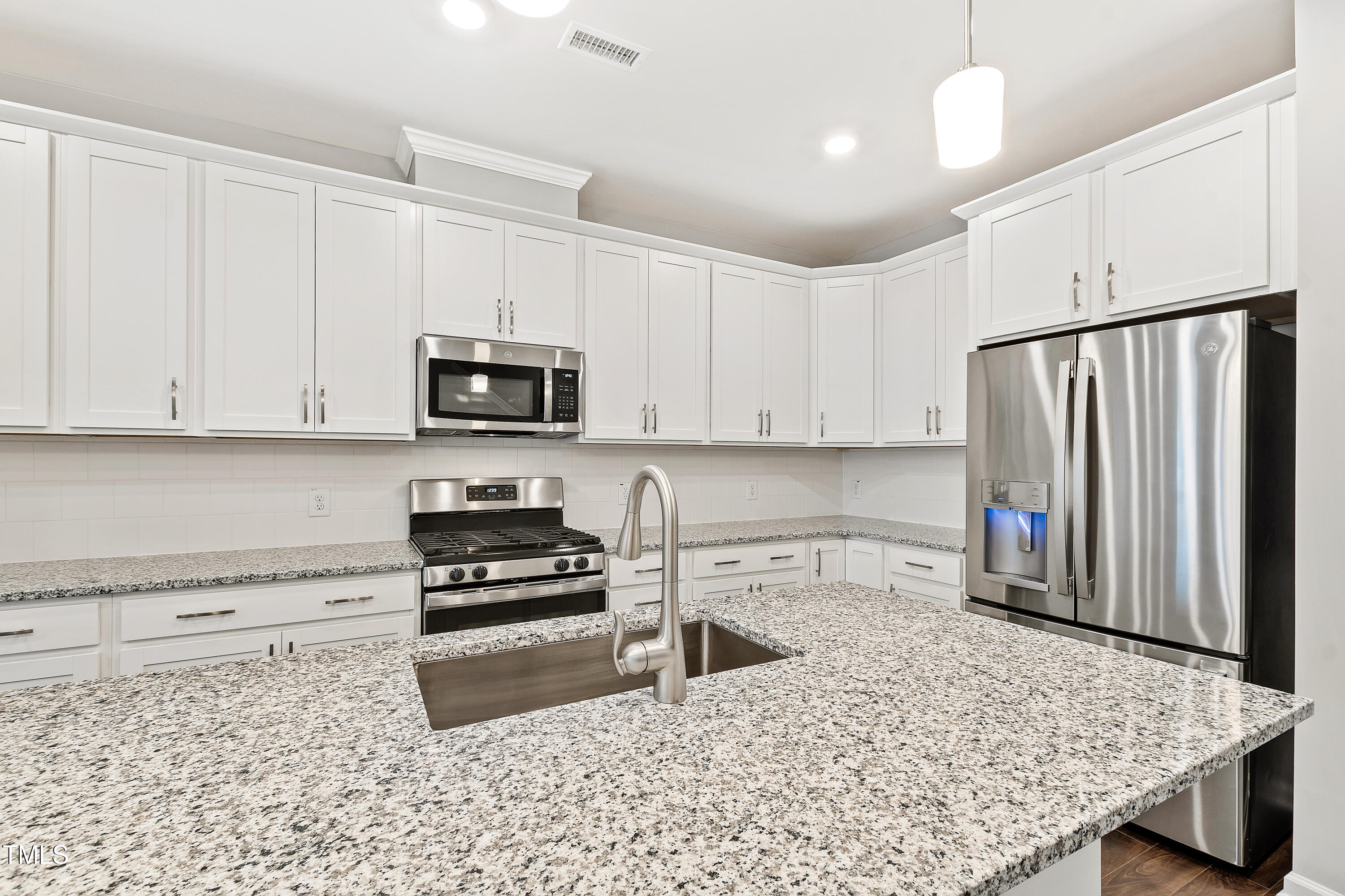 1102 Harmony Trail Durham, NC 27703 - Photo 7 of 33 a kitchen with granite countertop a refrigerator and a stove top oven