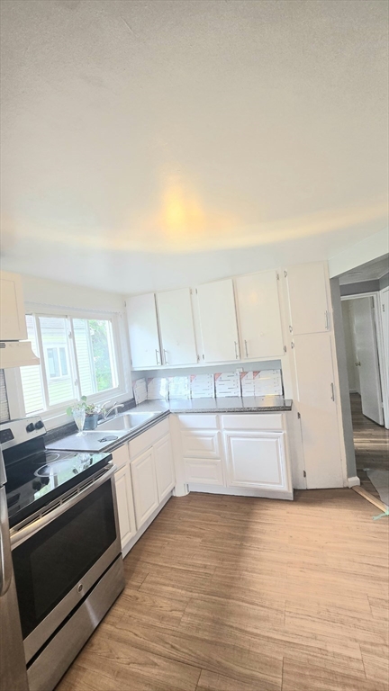 11 Stow Road Boston, MA 02126 - Photo 5 of 25 a kitchen with stainless steel appliances granite countertop a stove a sink and a microwave