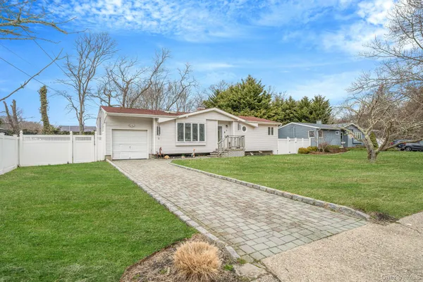 a view of house with a big yard and large tree