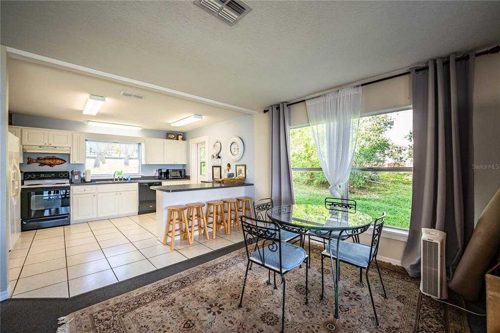 1702 North Scenic Highway Babson Park, FL 33827 - Photo 12 of 46 a kitchen with stainless steel appliances granite countertop a stove a refrigerator a kitchen island a table and chairs in it