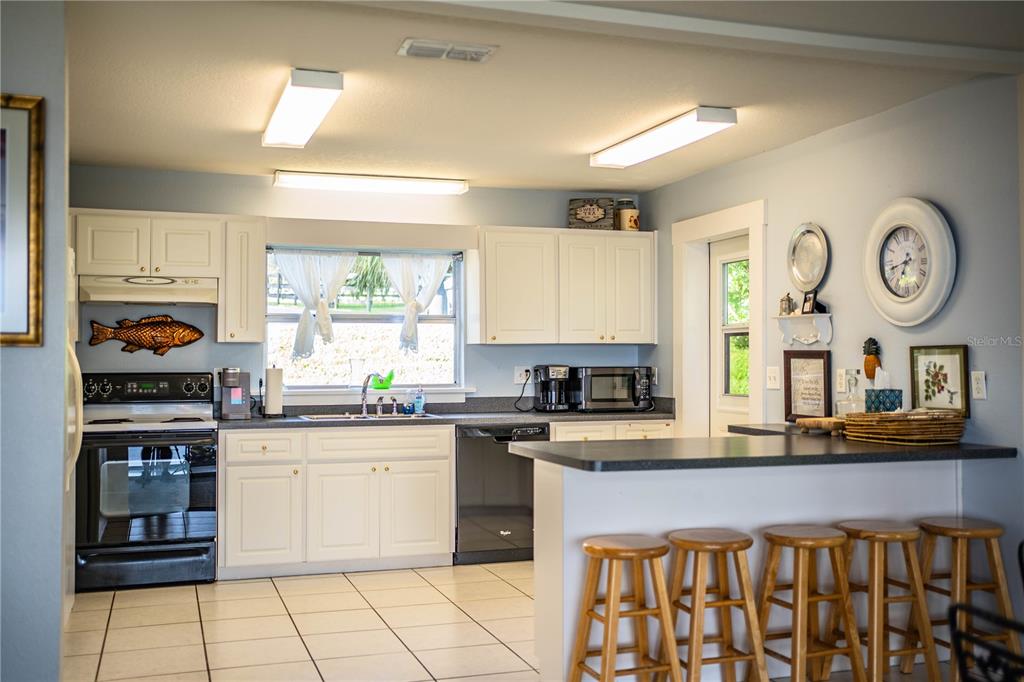 1702 North Scenic Highway Babson Park, FL 33827 - Photo 14 of 46 a kitchen with stainless steel appliances granite countertop a stove a sink and a microwave