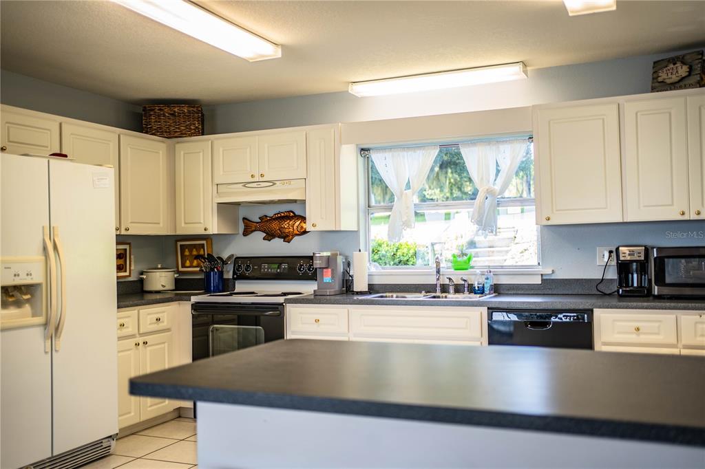 1702 North Scenic Highway Babson Park, FL 33827 - Photo 21 of 46 a kitchen with stainless steel appliances granite countertop a stove a sink and a microwave