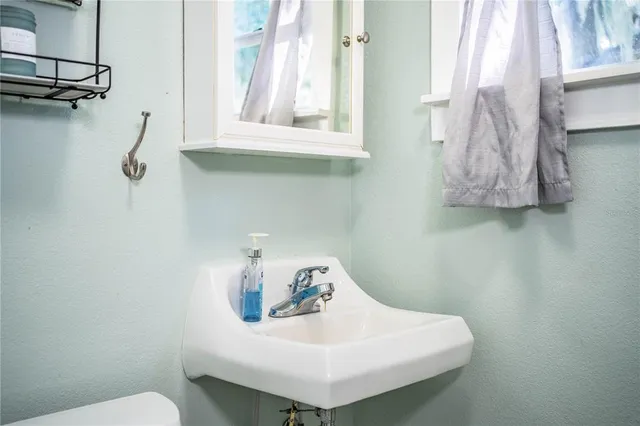 a bathroom with a sink a toilet and a window