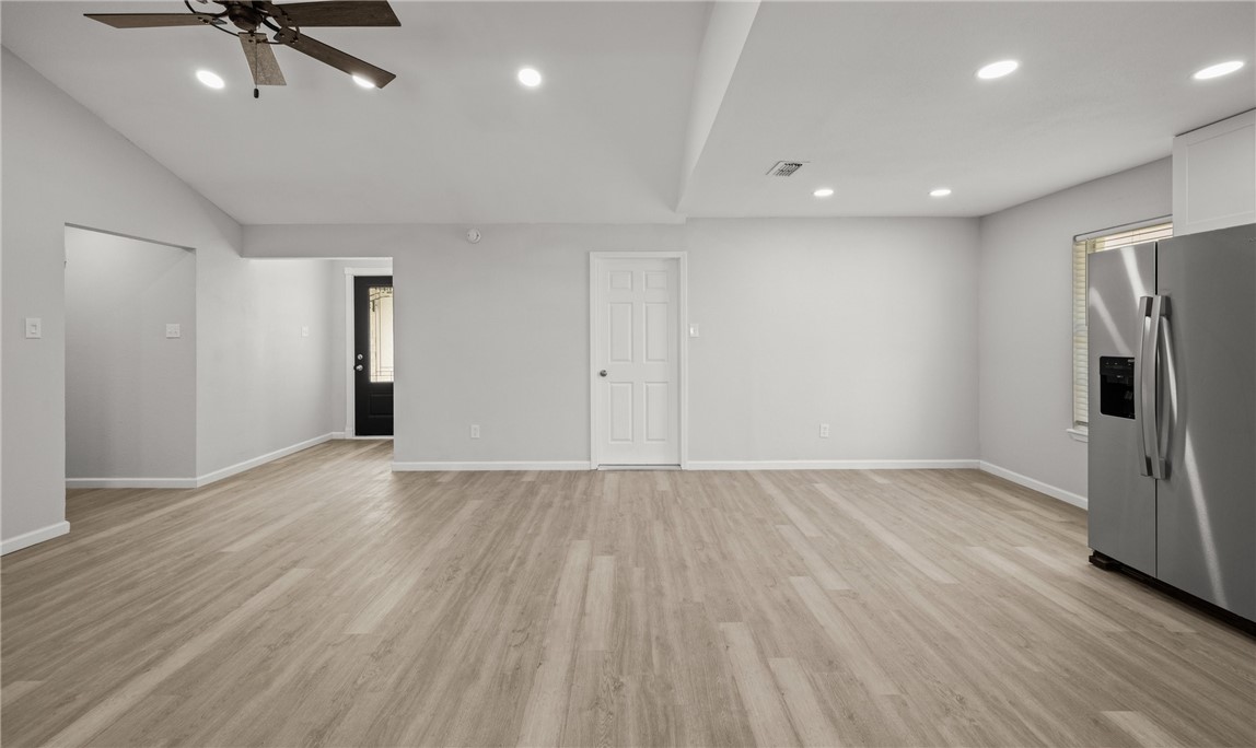 1021 Espana Drive Portland, TX 78374 - Photo 4 of 10 an empty room with wooden floor and a ceiling fan