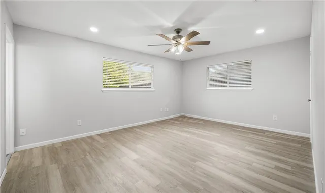 an empty room with a window and a fan