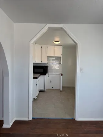 a view of a kitchen with white cabinets and a sink
