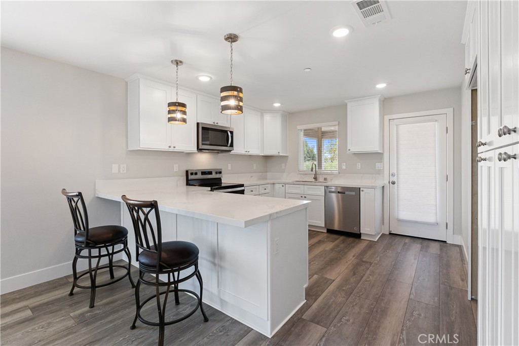 6018 William Street Riverside, CA 92504 - Photo 12 of 59 a kitchen with a sink cabinets and wooden floor