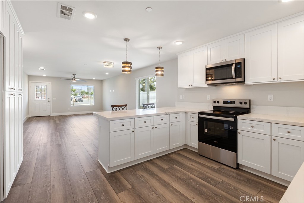 6018 William Street Riverside, CA 92504 - Photo 13 of 59 a kitchen with a white cabinets and black appliances