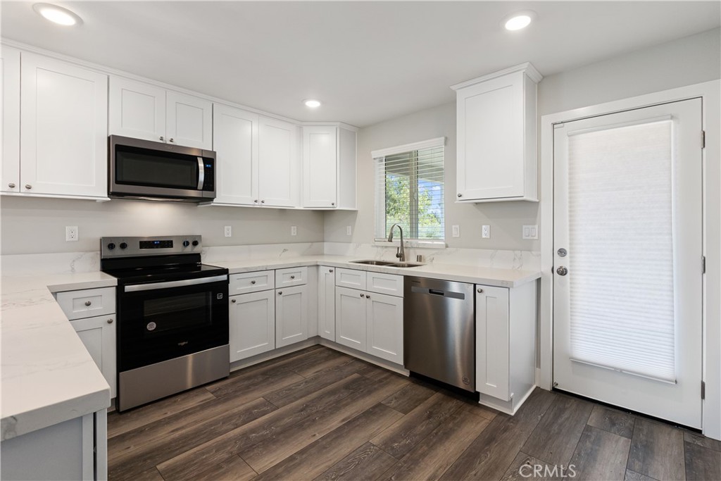 6018 William Street Riverside, CA 92504 - Photo 16 of 59 a kitchen with granite countertop white cabinets and stainless steel appliances