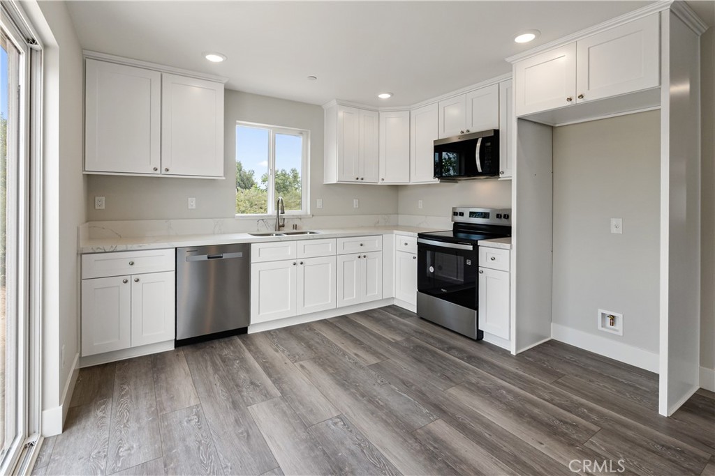 6018 William Street Riverside, CA 92504 - Photo 38 of 59 a kitchen with stainless steel appliances granite countertop white cabinets a sink a stove a refrigerator and a microwave