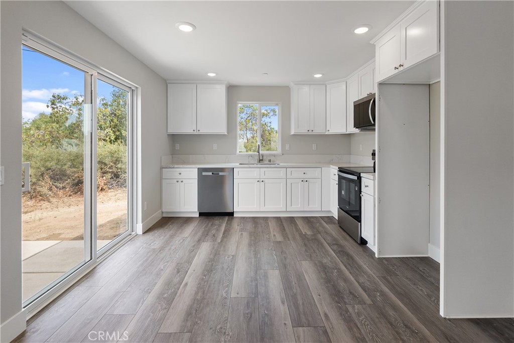 6018 William Street Riverside, CA 92504 - Photo 39 of 59 a kitchen with stainless steel appliances granite countertop a refrigerator a sink dishwasher a stove and white countertops with wooden floor