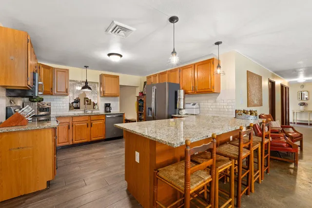 a kitchen with granite countertop a sink stainless steel appliances and cabinets
