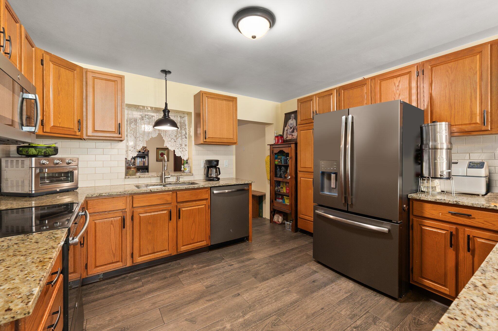 340 North Ffa Road Fort Pierce, FL 34945 - Photo 15 of 72 a kitchen with stainless steel appliances granite countertop a refrigerator stove microwave and sink